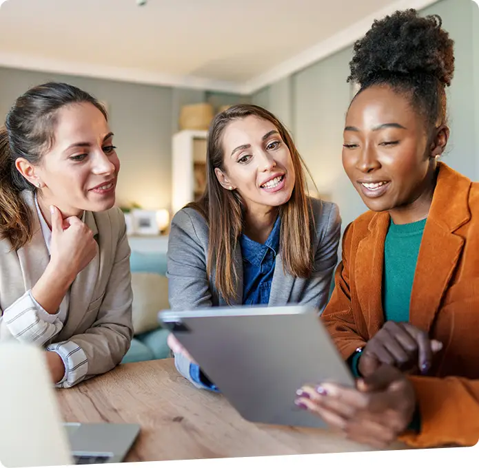 A group of businesswomen reviewing an Ipad and having a discussion