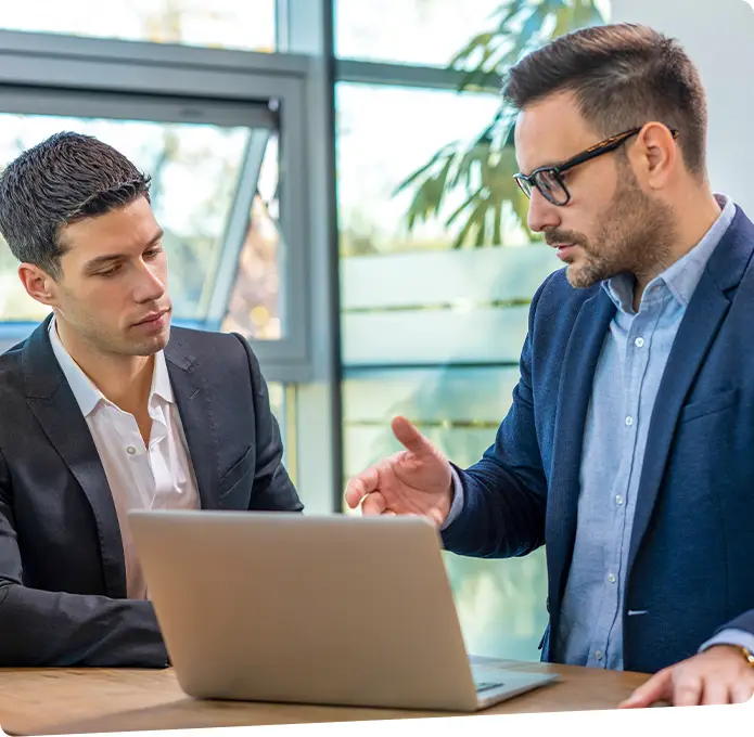 Two businessmen having a discussion while looking at a laptop